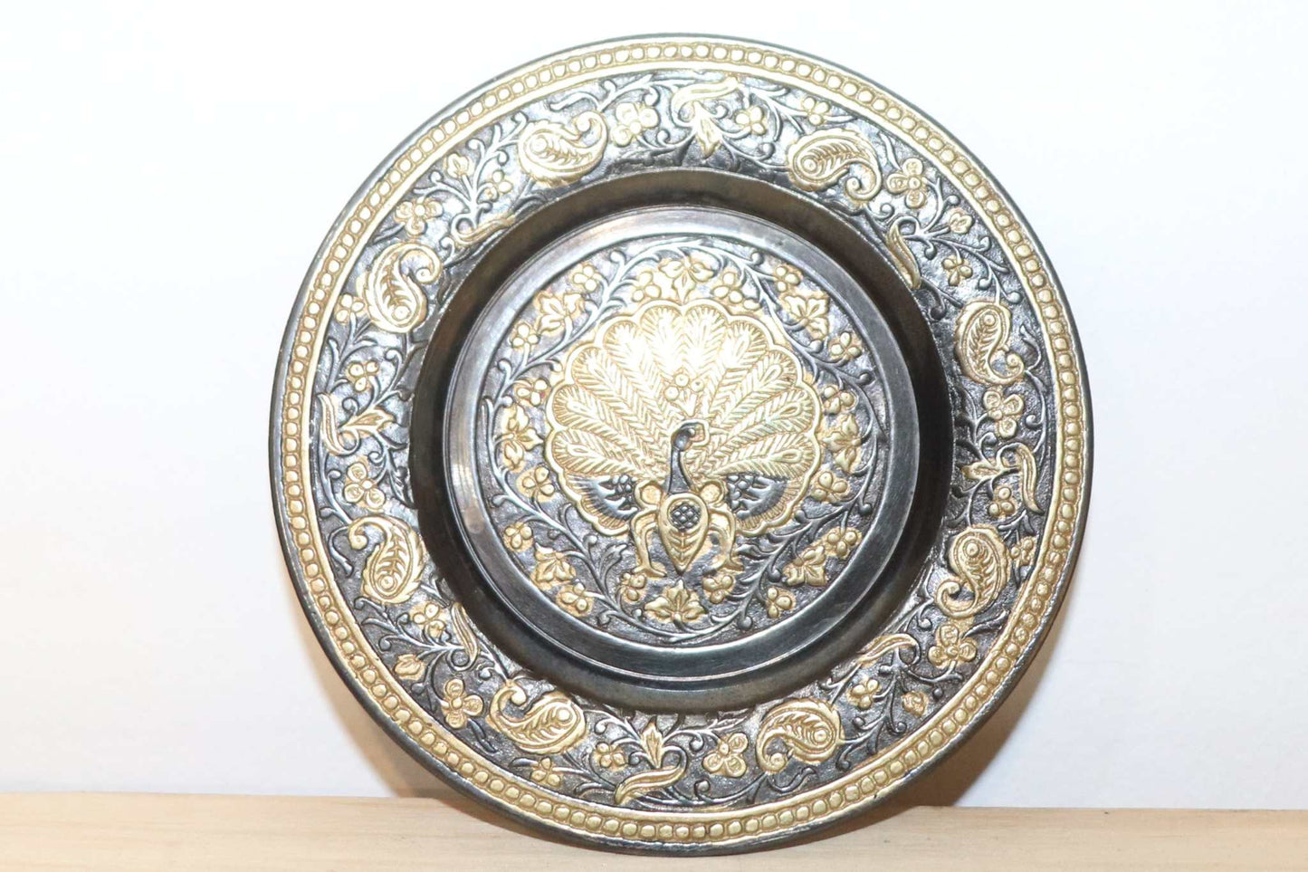 Vintage Brass Wall Plate of Indian origin Peacock center design with wall hanging attachment. Item measures 4 inches circle and is very detailed